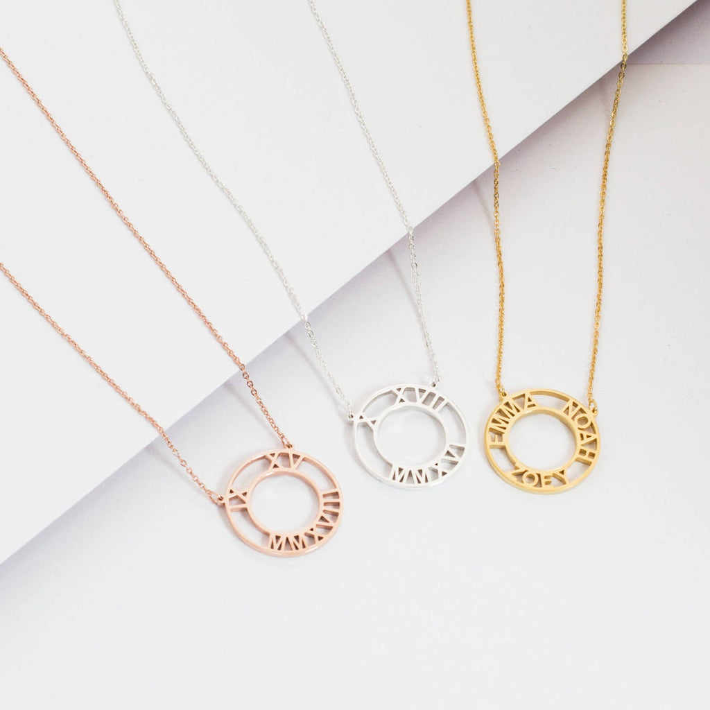 Three Roman Numerals Necklaces in rose gold, silver, and gold are displayed on a white background.