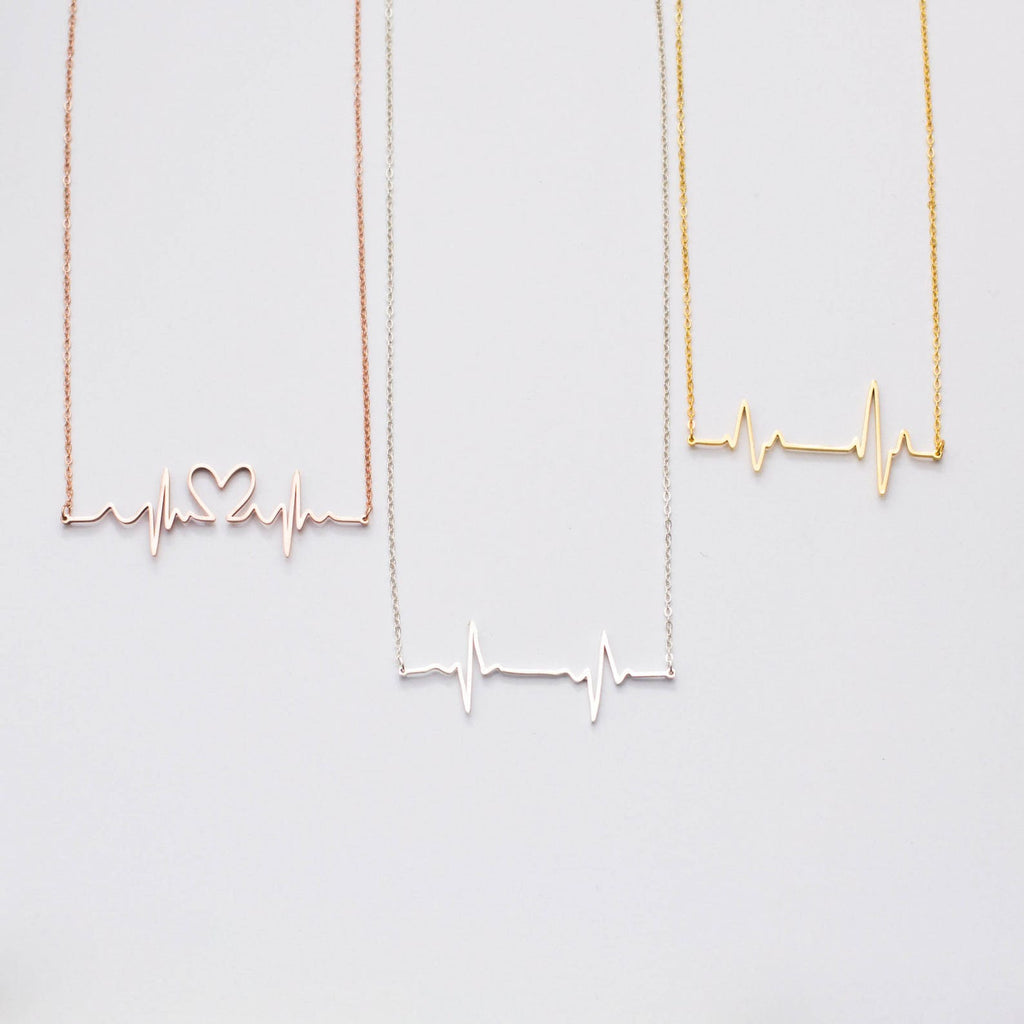The Heartbeat Necklace features three pendants—one heart-shaped, one plain, and one gold—making it a unique piece of voice jewelry and a thoughtful personalized gift.