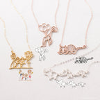 The Kids Drawing Necklace in Rose Gold features a unique, hand-drawn design inspired by children's art, paired with matching sketches on a light background—making each necklace a one-of-a-kind piece of wearable art.