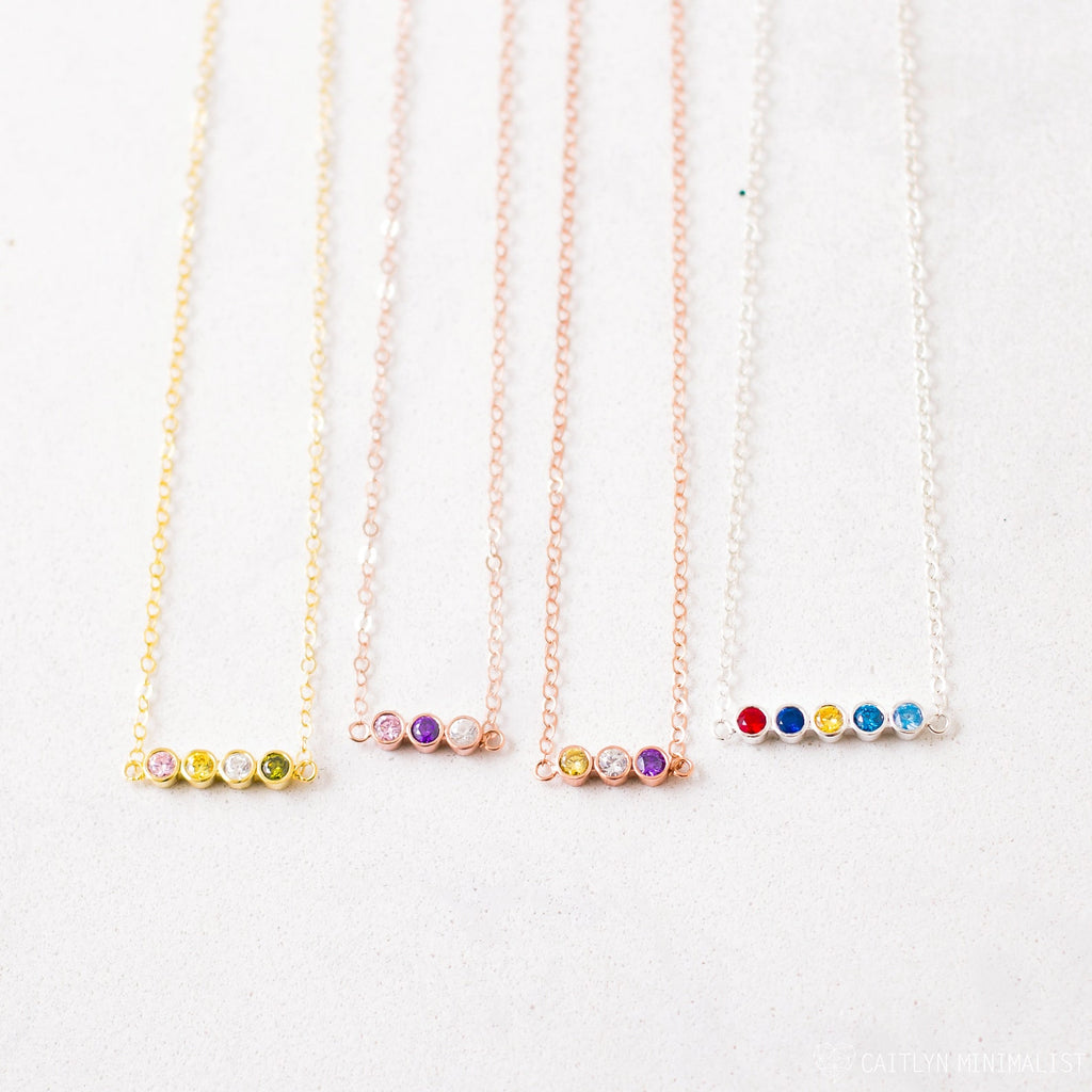 Four delicate chain necklaces, each with four colorful gemstone beads, displayed side by side—Multiple Birthstone Necklace, the perfect personalized gift for new moms or anyone wanting a meaningful custom birthstone necklace.