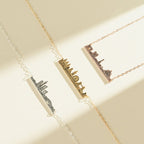 Three City Skyline Necklaces in silver, gold, and rose gold rest on a neutral background—an elegant accessory and thoughtful personalized gift.