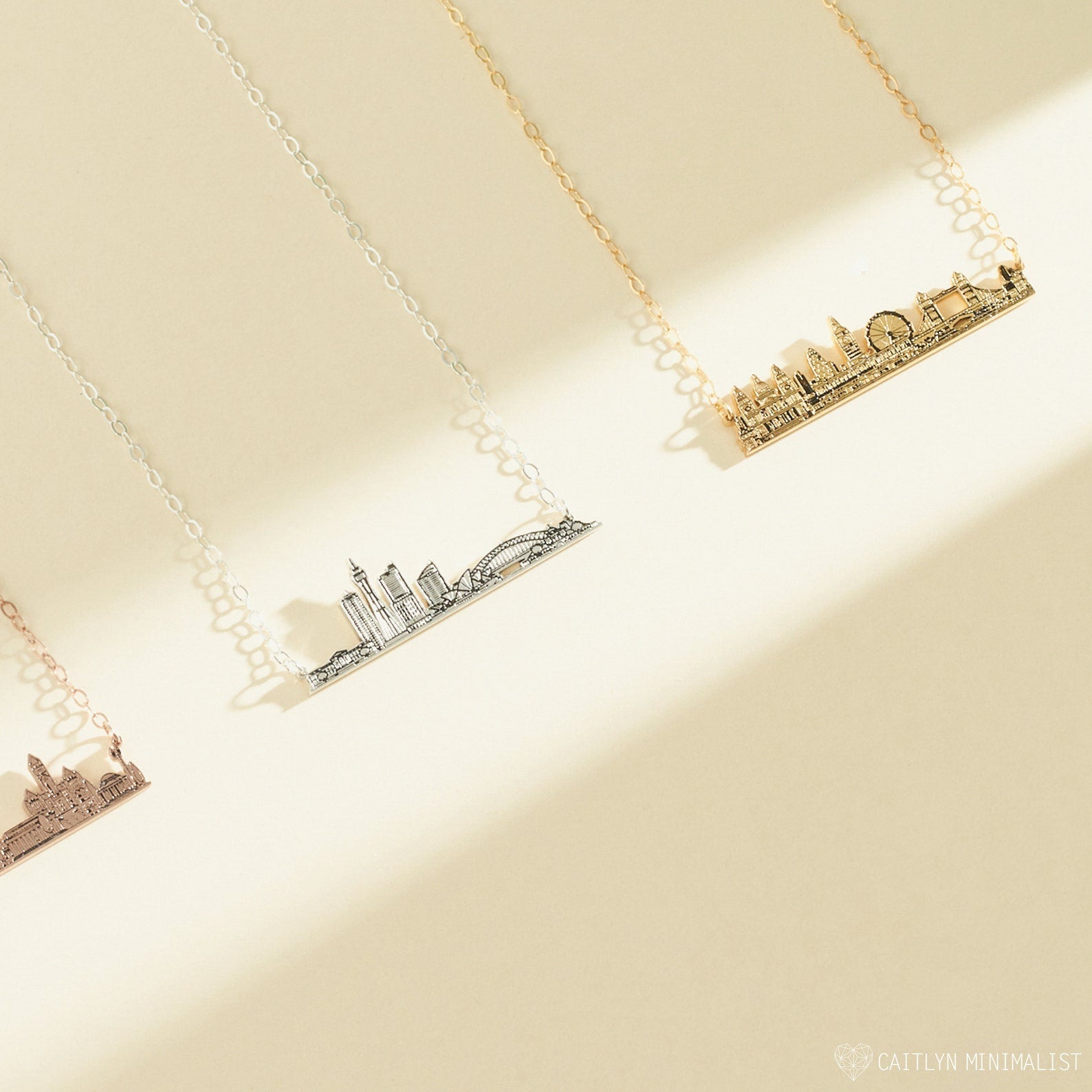The City Skyline Necklace is available in gold, silver, and rose gold, shown on a beige background—an elegant and personalized cityscape necklace, perfect as a thoughtful gift.