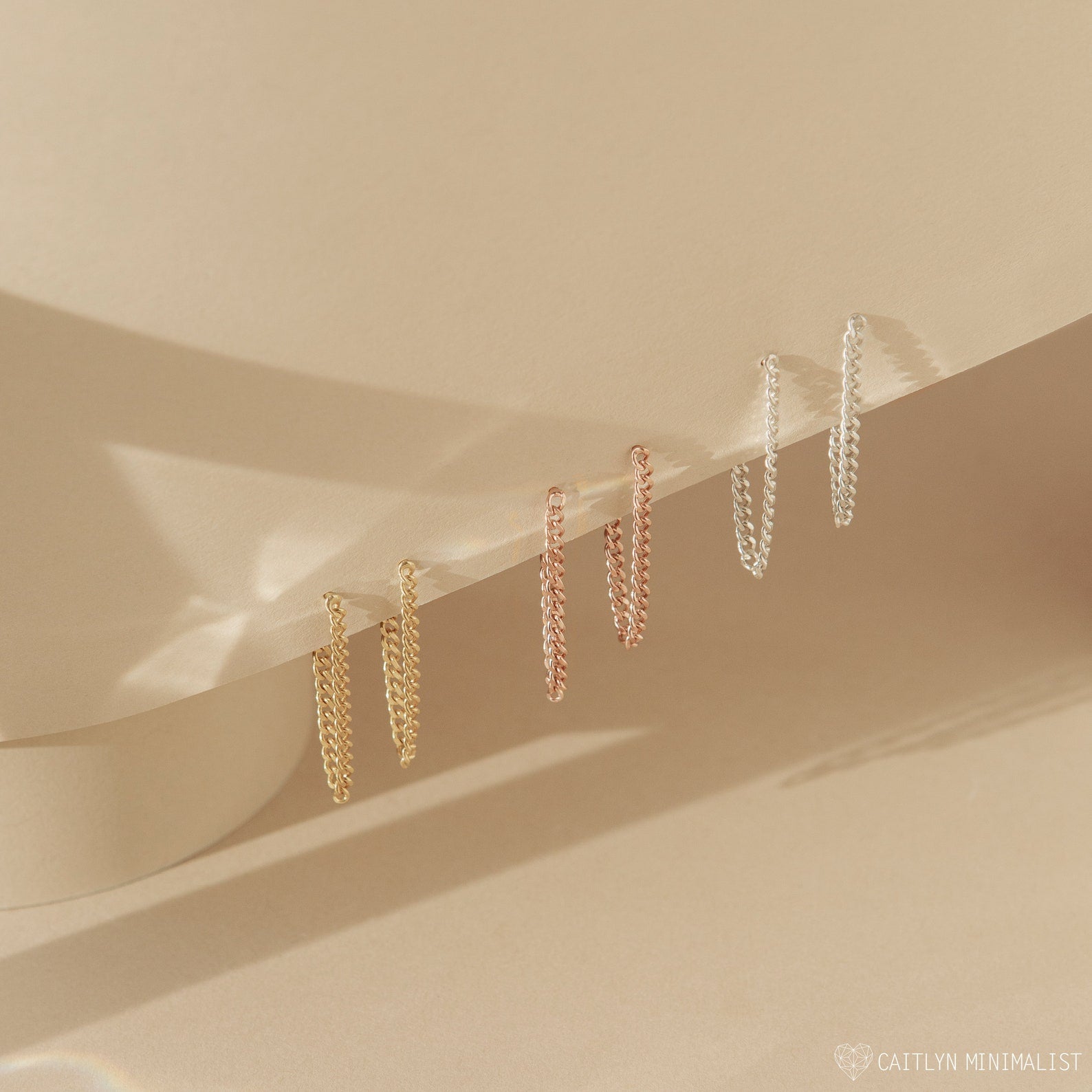 Three pairs of Curb Chain Stud earrings in gold, rose gold, and silver displayed on a light beige surface—versatile earrings perfect for any occasion or as a personalized gift.
