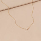 Delicate sterling silver Emery Necklace with a small rectangular pendant on a soft beige fabric—a perfect minimal accessory and thoughtful holiday gift.