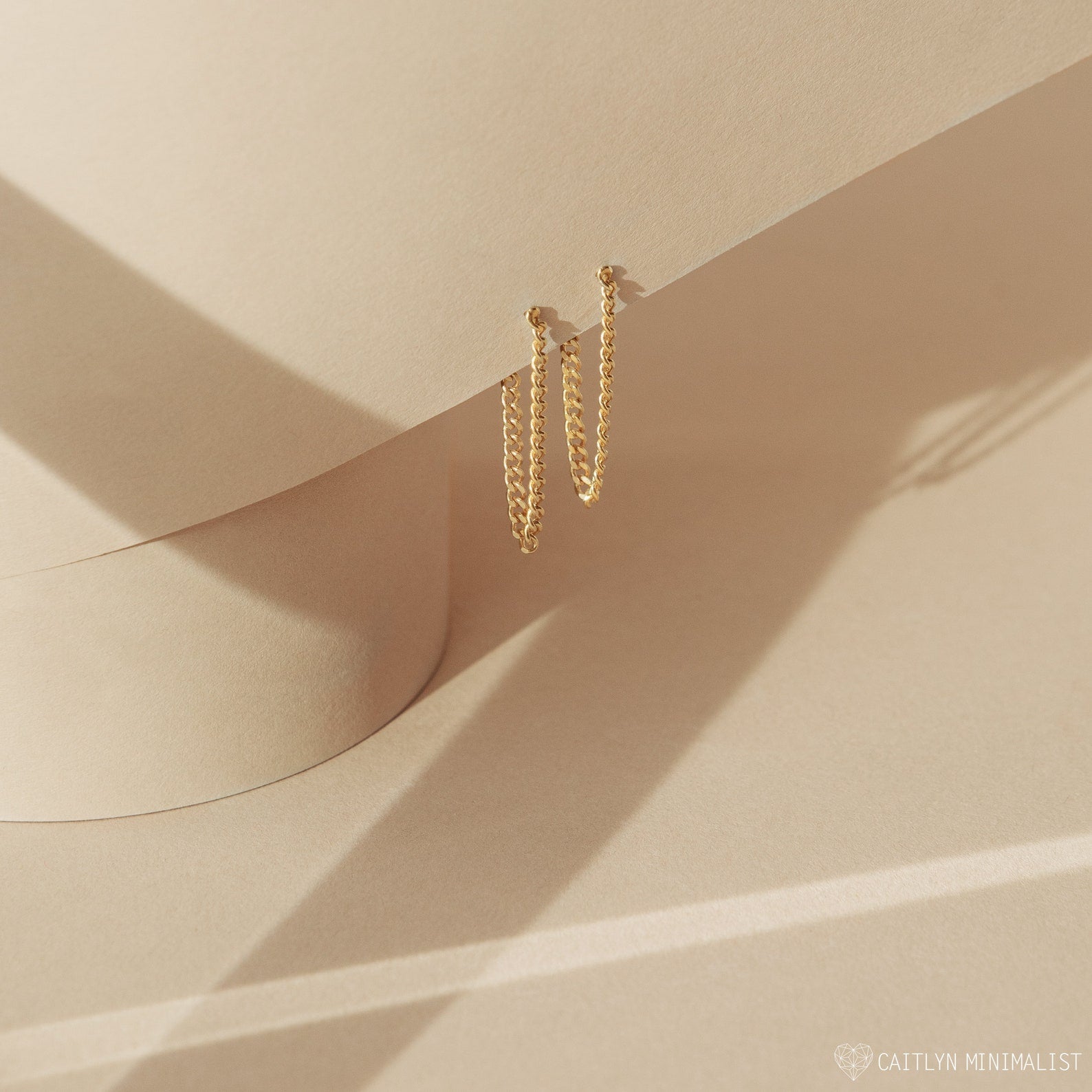 Curb Chain Studs hoop earrings are shown on a beige abstract background with soft shadows—versatile and stylish, they’re the perfect personalized gift.