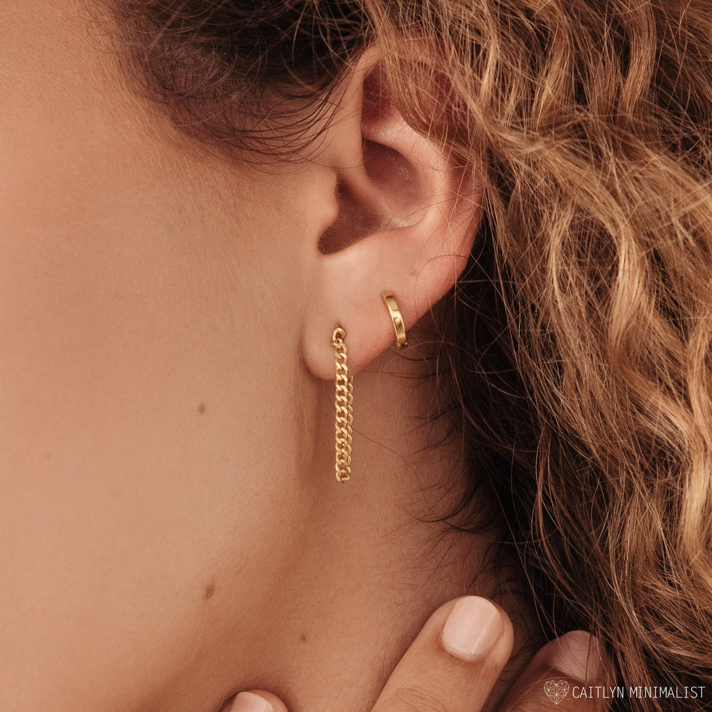 Close-up of a woman's ear with Curb Chain Studs and a classic hoop earring peeking through curly hair—an elegant and personal gift idea.