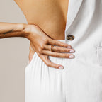 A woman with her hand on her waist radiates modern luxury, flaunting the elegant Baguette Eternity Ring.