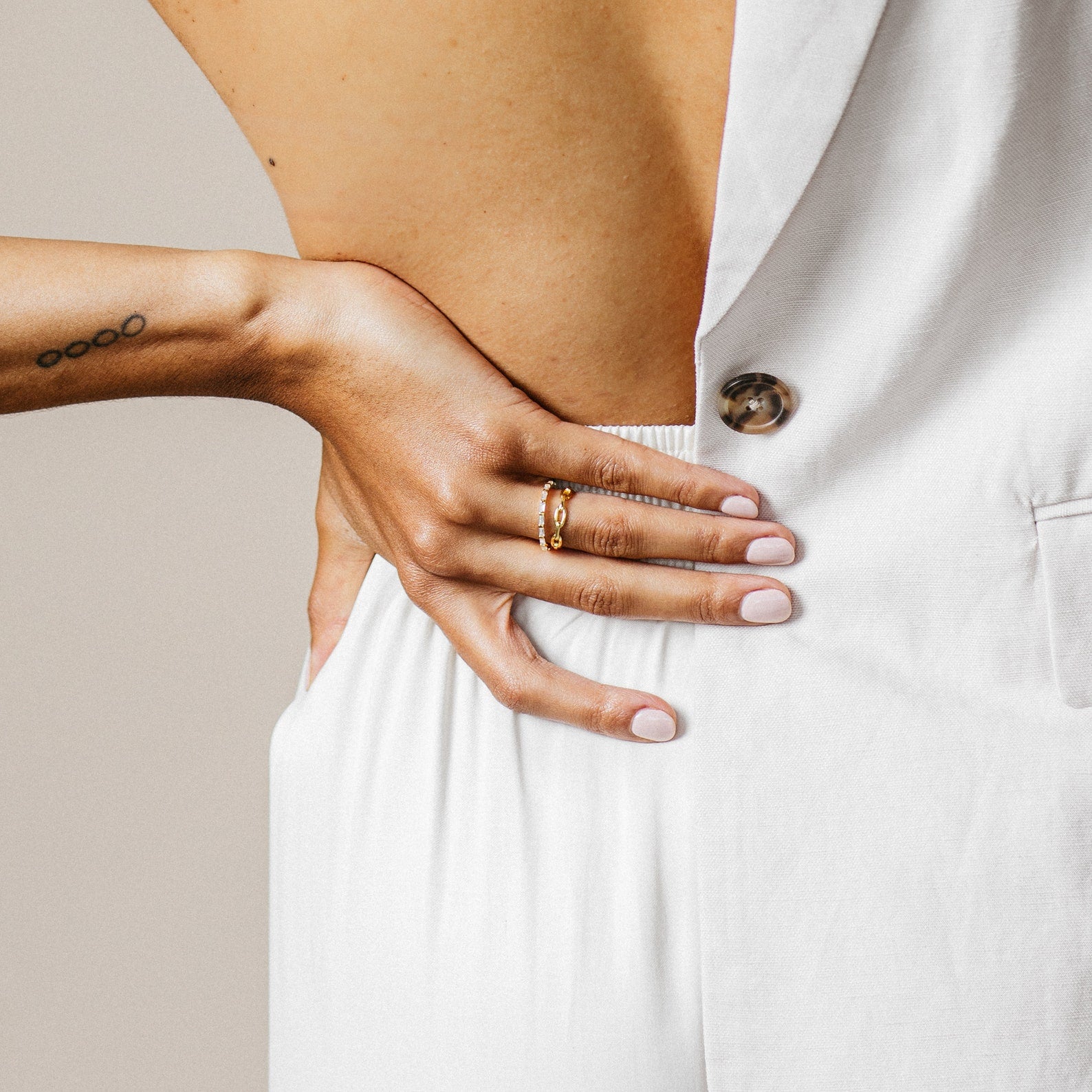 A woman with her hand on her waist radiates modern luxury, flaunting the elegant Baguette Eternity Ring.