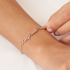 A hand fastens a Classic Multiple Name Bracelet, personalized with the names Kelly, Faith, and Carla, onto a wrist.