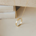 The Inner Circle Necklace in gold showcases a circular pendant engraved with "NICHOLE," set against a neutral background.