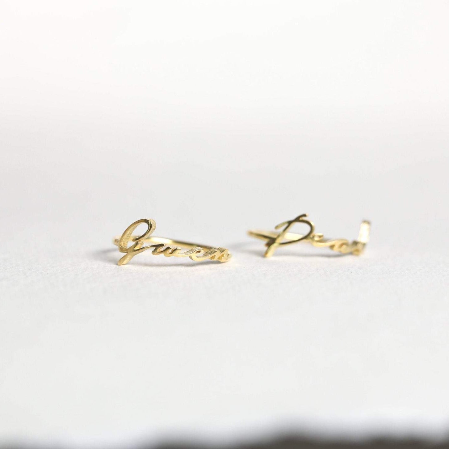 Two delicate Venice Name Rings in elegant cursive, shown on a light background—perfect custom jewelry pieces.