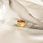 Four Alice Thin Engraved Rings, each personalized with a name, are stacked on soft ivory fabric in elegant lighting—a beautiful minimal ring set and the perfect custom gift.