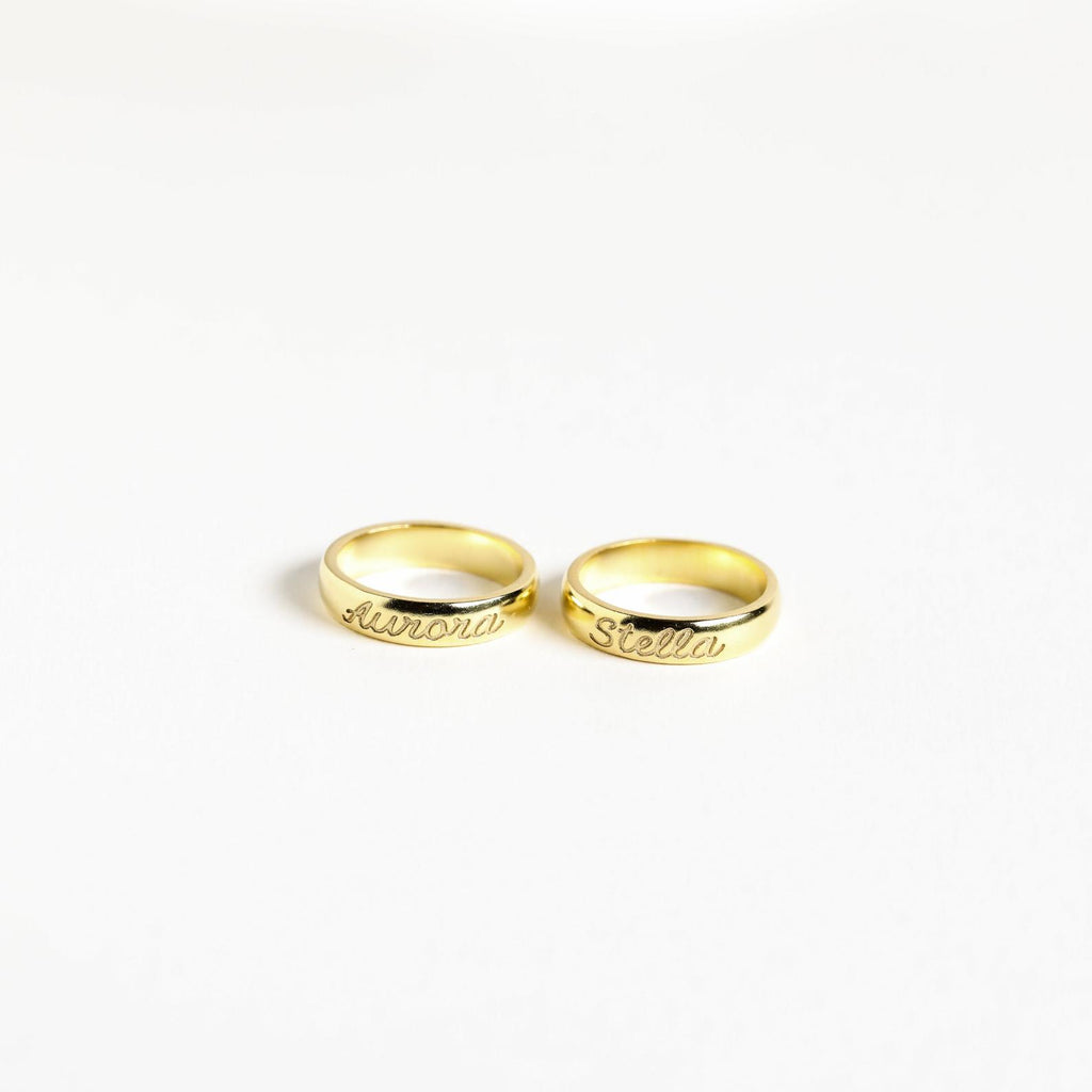 Two Ann Half Round Rings in a classic style, each personalized with the names “Aurora” and “Stella,” displayed on a white background.