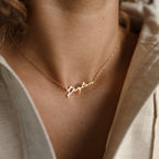 The Venice Name Necklace features the name Peyton in elegant script, worn as delicate jewelry around a woman’s neck.