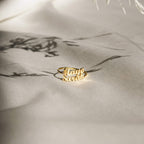 The London Duo Name Ring, featuring Maya and Sarah in elegant script, rests on soft cream fabric—a stunning custom jewelry piece that celebrates your unique bond.