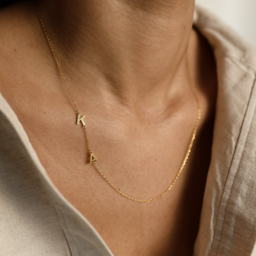 The Sideways Initial Necklace is a unique gift, featuring gold letter charms like "K" and "A" on a stylish chain—perfect as a thoughtful Christmas present.