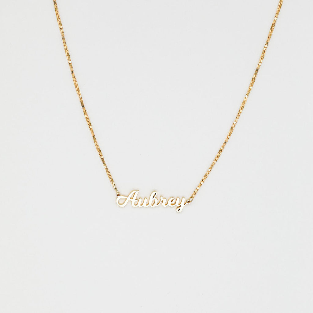 The Mellow Name Necklace in Box Chain features "Aubrey" in elegant cursive on a slim box chain, shown against a white background.