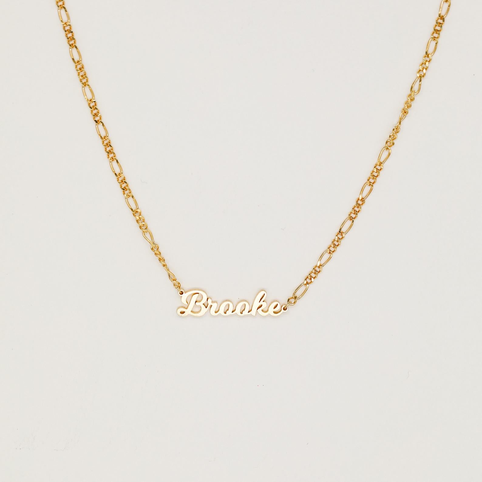 The Mellow Name Necklace in Figaro Chain features "Brooke" in elegant cursive, shown on a classic chain against a plain white background.