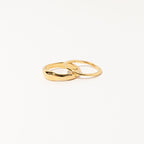 Two interlocking gold rings from the Duo Form Ring Set displayed on a clean white background.