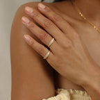 A hand adorned with the Gina Pave Signet Ring gently rests on the opposite shoulder, complementing neutral-toned clothing.