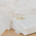Pave Round Studs featuring sparkling gems, showcased on a white textured surface against a soft background.