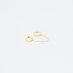 The Pave Duo Chain Earrings feature two small gold huggies linked by a delicate chain, with one hoop embellished with clear stones—perfect for styling with multiple ear piercings.