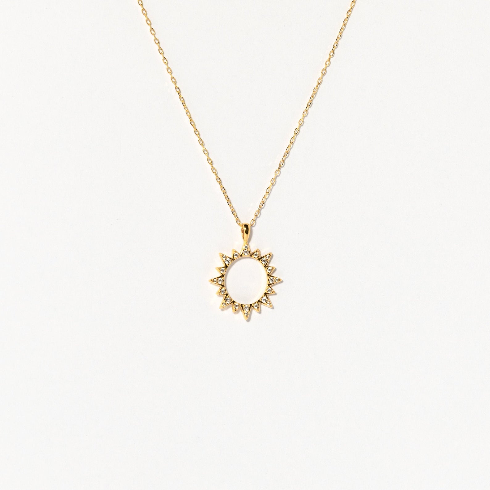 The Pave Sun Necklace features a sun-shaped pendant with pointed rays and subtle pave accents, shown against a plain white background.