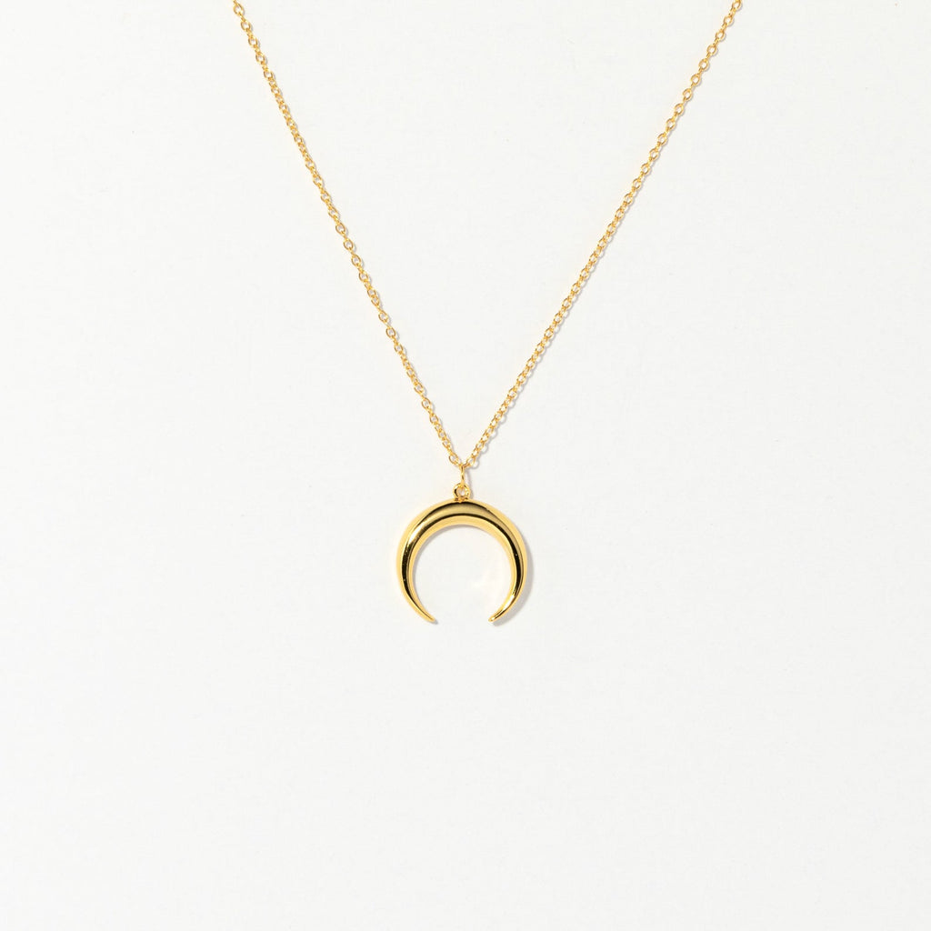 The Crescent Moon Necklace features a gold chain with a delicate crescent moon pendant, shown on a plain white background.