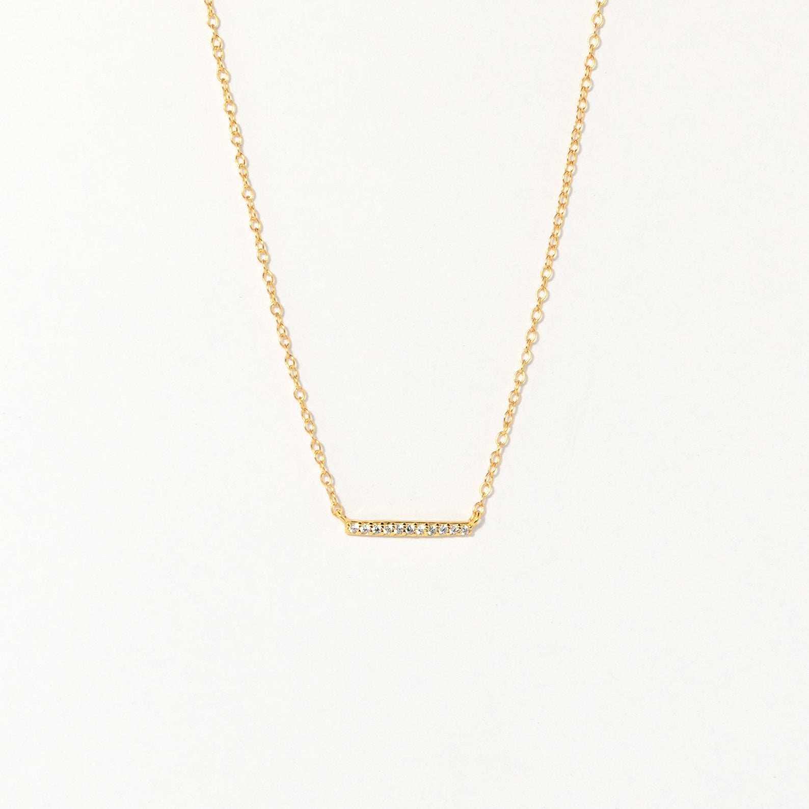 The Pave Bar Necklace features a gold chain with a petite, sparkling bar pendant—ideal for adding subtle shine to your look or layering with other necklaces.