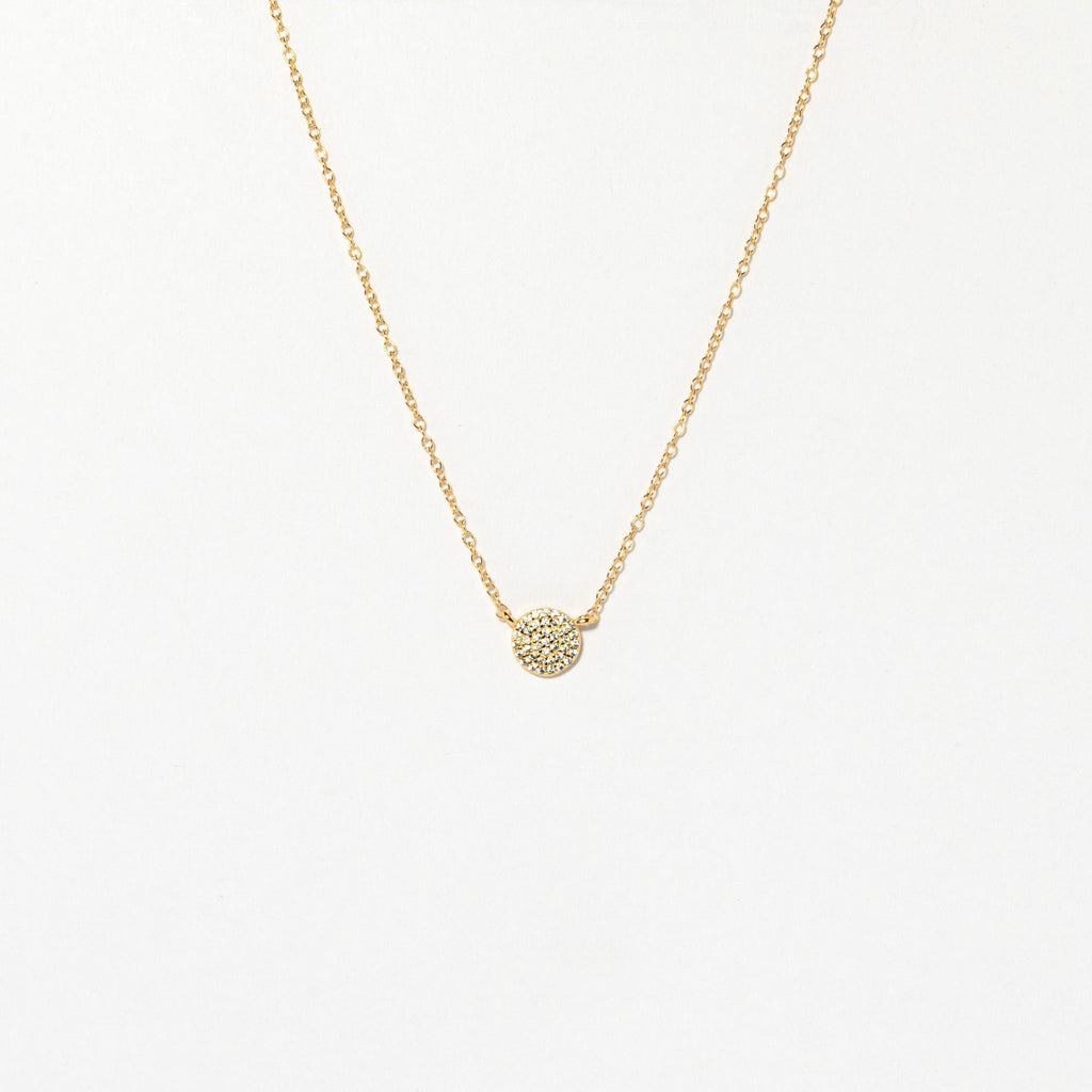 The Pave Round Necklace features a gold chain with a small, pavé-encrusted circle pendant, shown on a plain white background.
