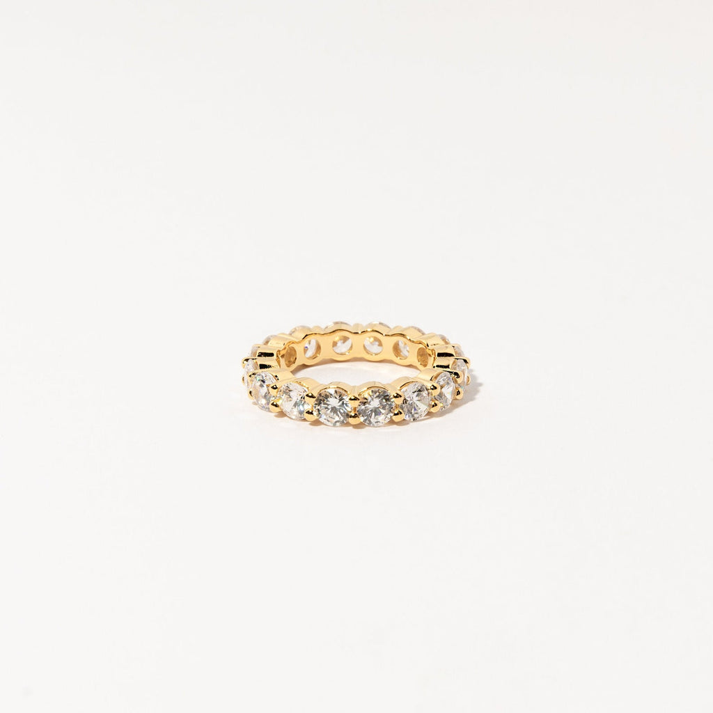 The Christy Ring features a full circle of round, sparkling diamonds set in a gold band—ideal for feminine jewelry lovers to wear solo or stacked. Shown against a white background.