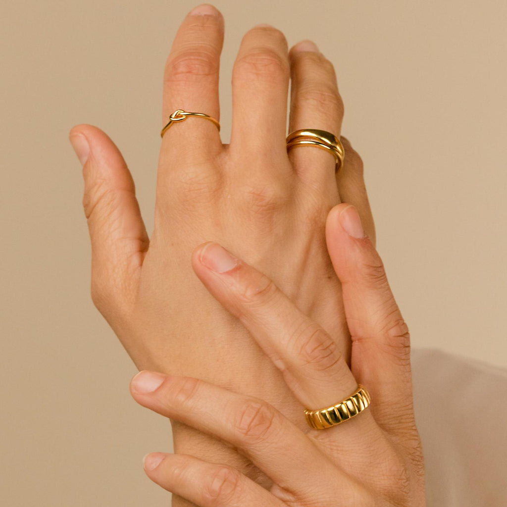 Hands adorned with the Duo Form Ring Set and other delicate gold rings, styled in a minimalist aesthetic.