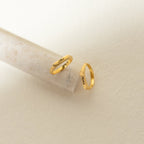 Two Paris Thin Name Signet Rings engraved with “Elle” rest on a light stone and cream backdrop—ideal for stacking or as a timeless statement piece.