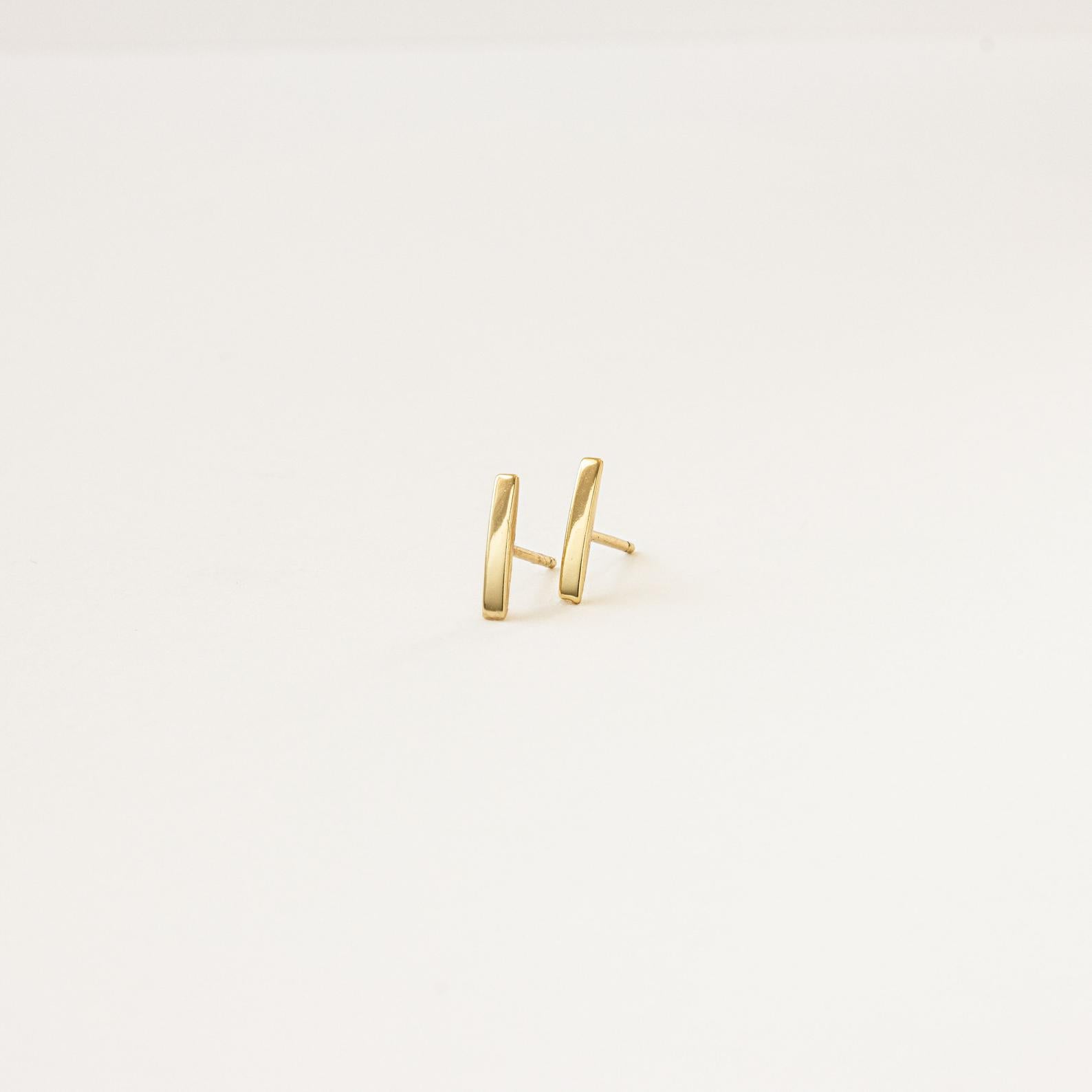 Dainty Bar Studs: these minimalist earrings are perfect for an effortless earring stack, shown on a plain light background.
