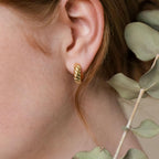 A close-up of a woman's ear wearing Morgan Croissant Hoops, capturing the effortless charm of the French girl aesthetic.