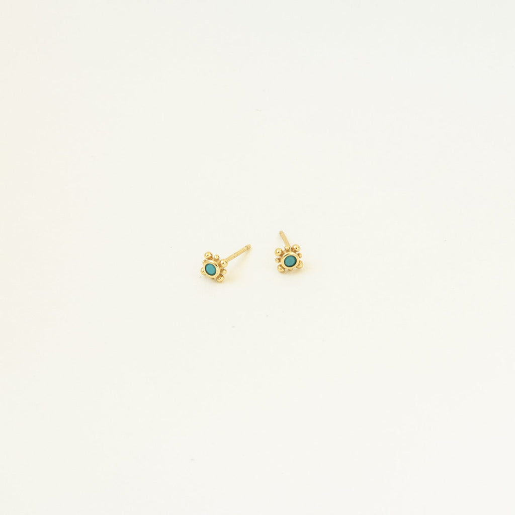 Mara Studs: Small gold studs featuring a vibrant turquoise stone at the center, displayed on a plain white background.