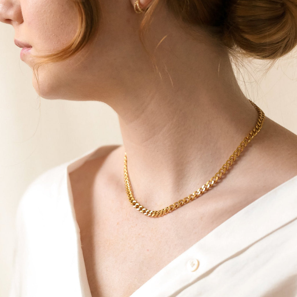 A close-up of the gold curb chain necklace worn on a woman
