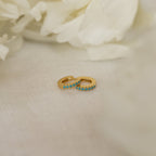 The Kendra Huggies, small gold turquoise earrings with vibrant stones, set on soft white fabric and accented by white flowers, bring eclectic charm to any look.