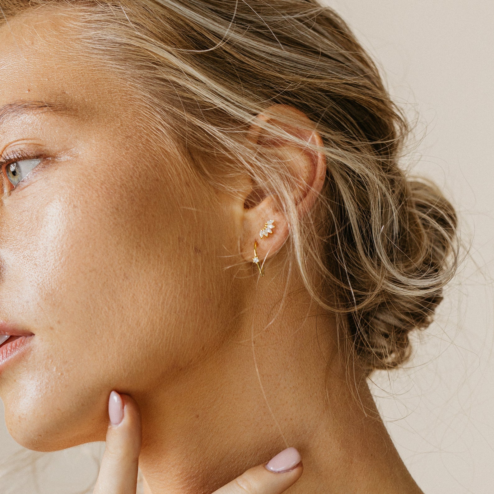 A close-up of a woman's face, elegantly adorned with Rylee Diamond Wire Earrings.