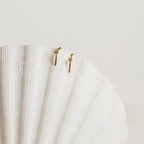 The Rylee Diamond Wire Earrings, a modern pair, displayed elegantly on a white shell.