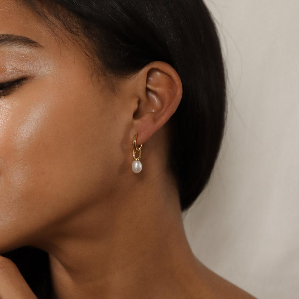 A woman wearing our Hazel Pearl Hoops, showcasing classic beauty with a modern twist from our signature jewelry collection.