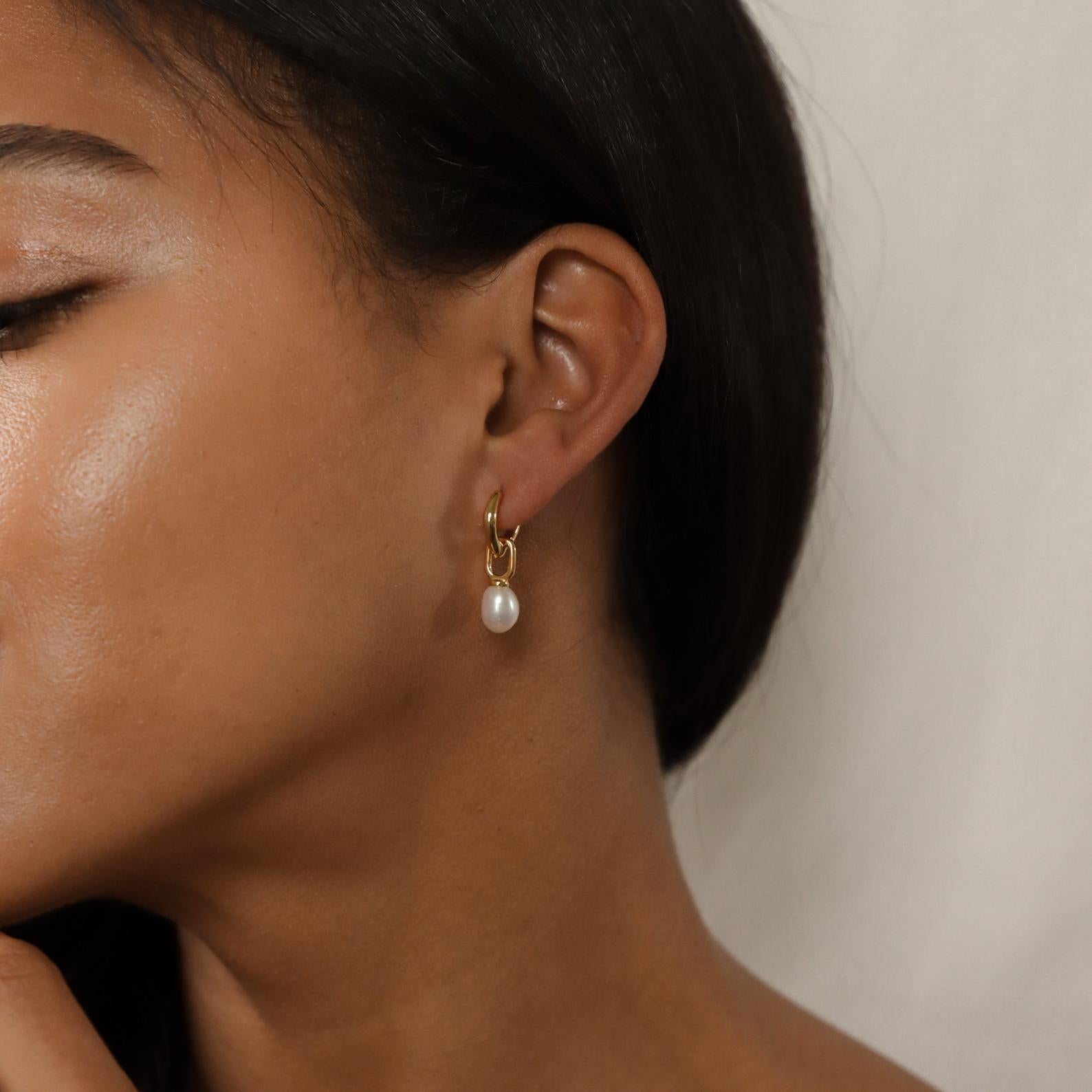 A woman wearing our Hazel Pearl Hoops, showcasing classic beauty with a modern twist from our signature jewelry collection.