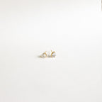 Pear Diamond Studs: Minimalistic gold earrings with small, heart-shaped clear stones, elegantly showcased on a plain white background.
