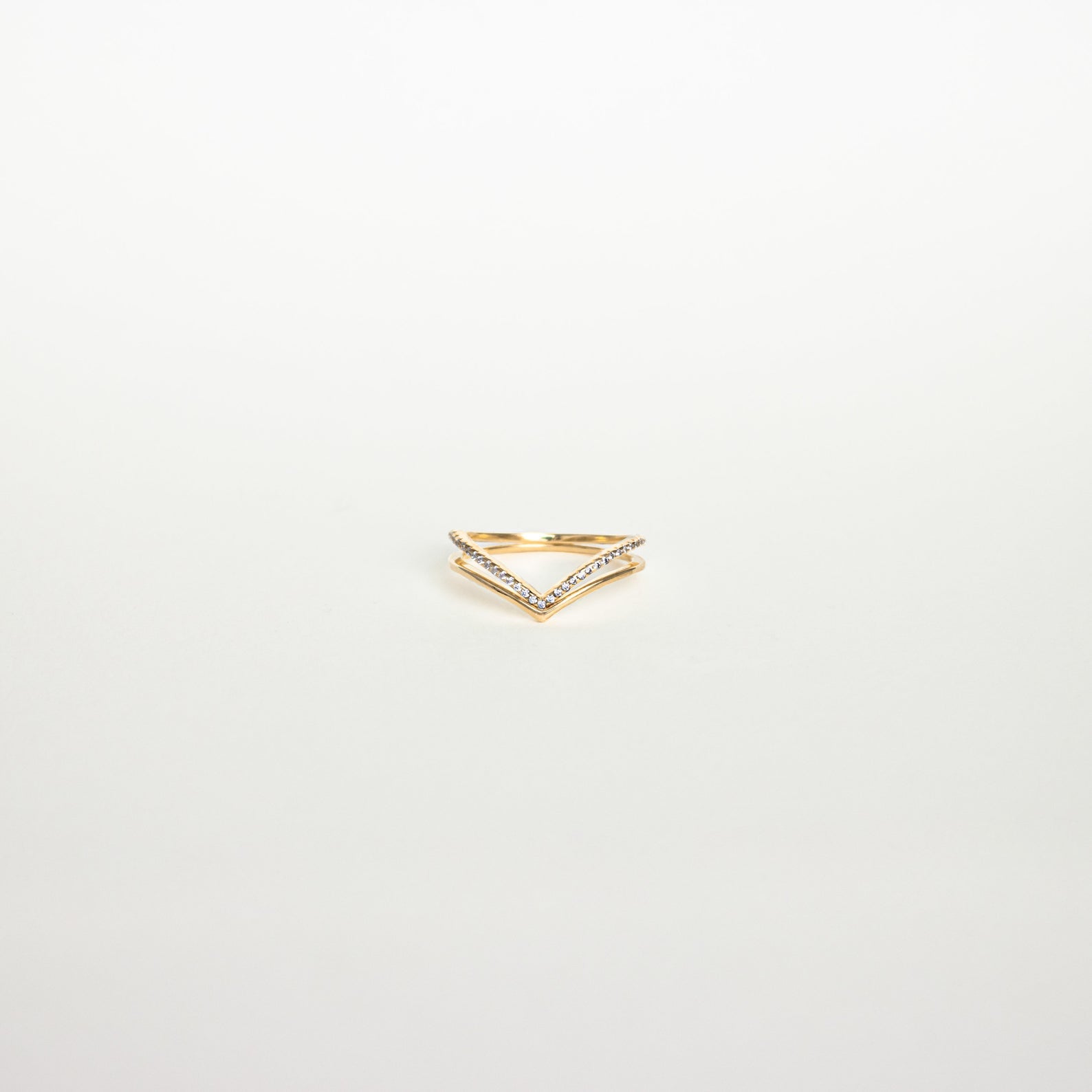 Curve Stacking Set: Gold chevron-shaped ring accented with small diamonds, ideal for stacking or as a curved band, photographed on a plain white background.