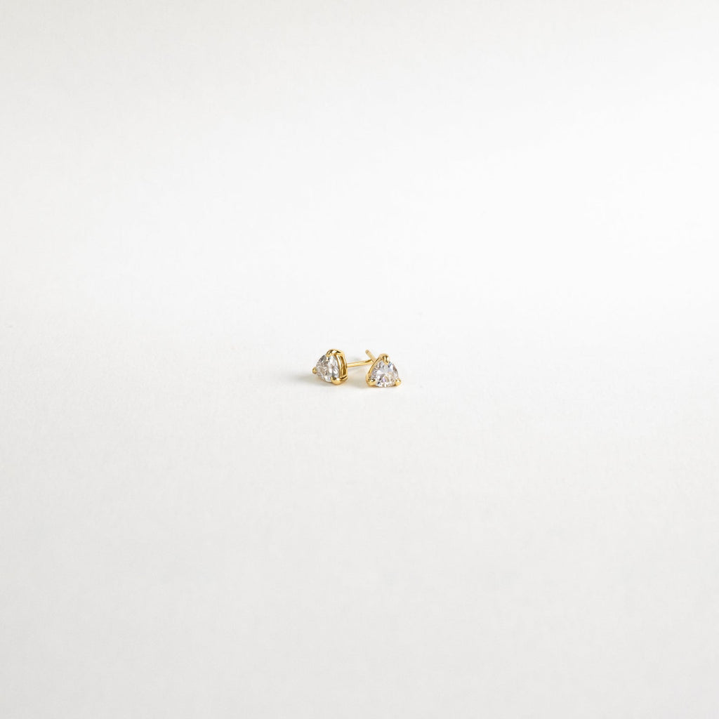Triangle Diamond Studs—small gold earrings with clear gemstones—add classic elegance to any look. Shown on a plain white background.