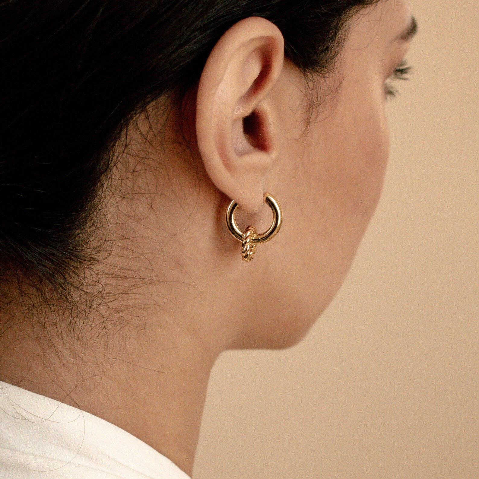 Close-up of a woman shown from behind wearing the Claire Duo Hoops, elegant gold earrings with a subtle twisted design.