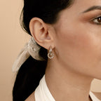 A woman wears Claire Duo Hoops, her dark hair styled with a light scarf for a chic jewelry statement.