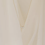 A delicate gold chain necklace featuring a small cluster of marquise-cut clear stones arranged like petals.