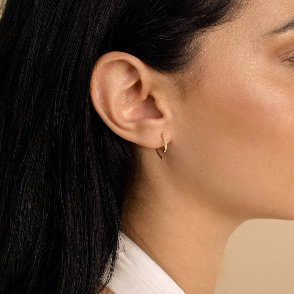Woman with long dark hair, shown in profile, wearing Pave Wire Diamond Hoops in her left ear.