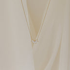 A delicate gold chain necklace featuring a small cluster of marquise-cut clear stones arranged like petals.